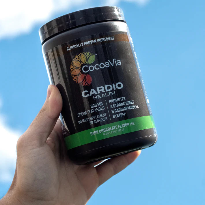 CocoaVia Cardio Powder bottle held against sky