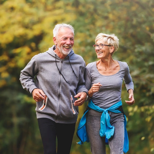 elderly couple running outside