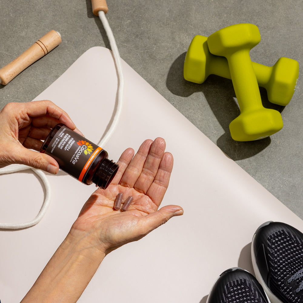 Pouring capsules into hand over workout equipment