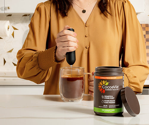 Woman frothing coffee with cocoavia powder