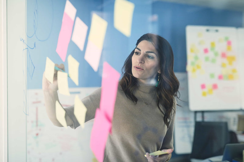 Woman looking at sticky notes on a board
